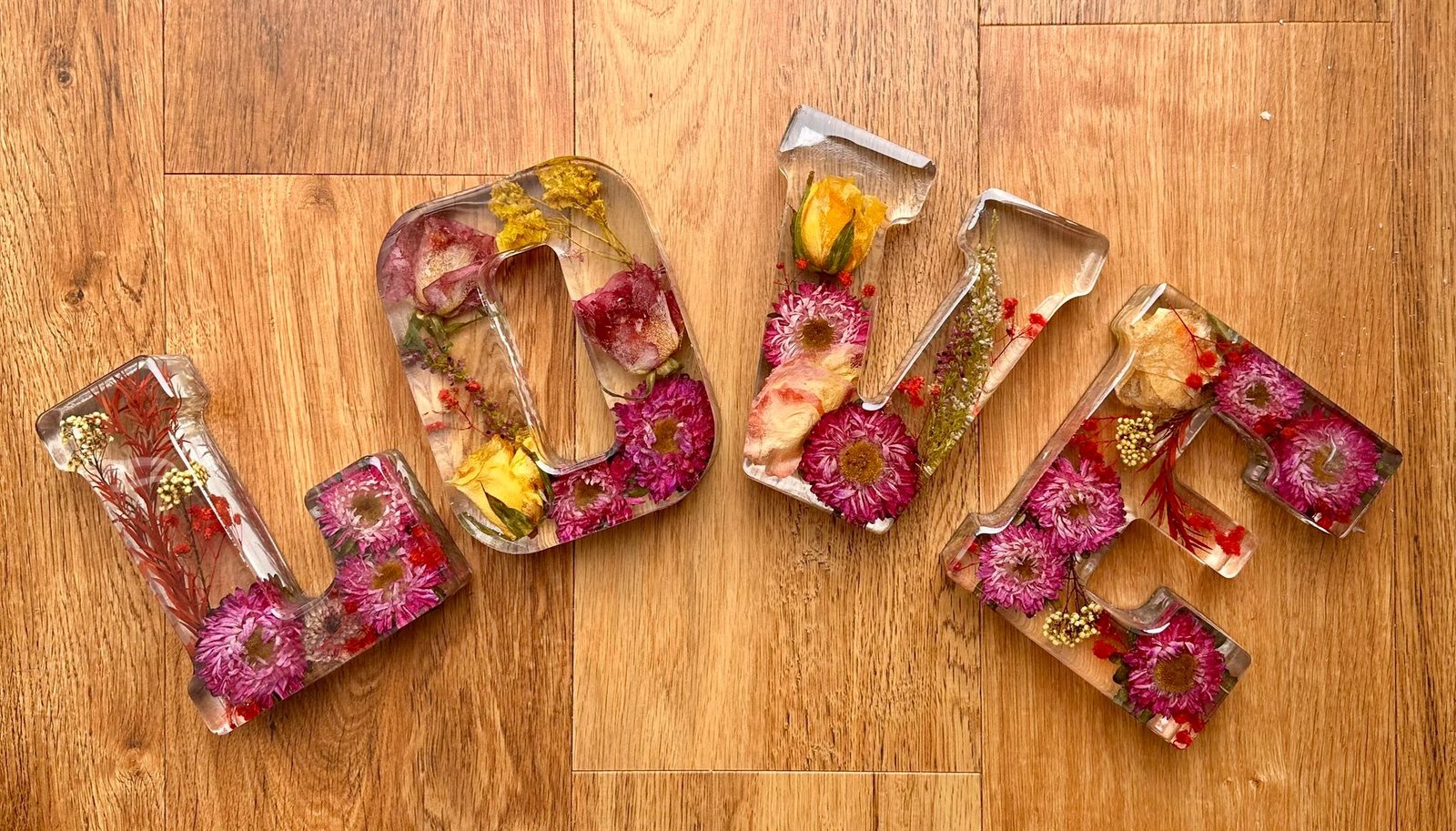 Resin flower preservation — red and gold oval paperweights